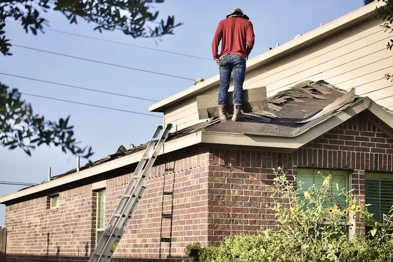 Professional roofer working on a residential roof in Woodsville